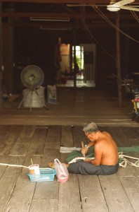 Avec un tel climat, les thaïlandais travaillent devant chez eux avec leur intérieur ouvert sur les allées. Ici, un homme rafistole un filet de pêche.