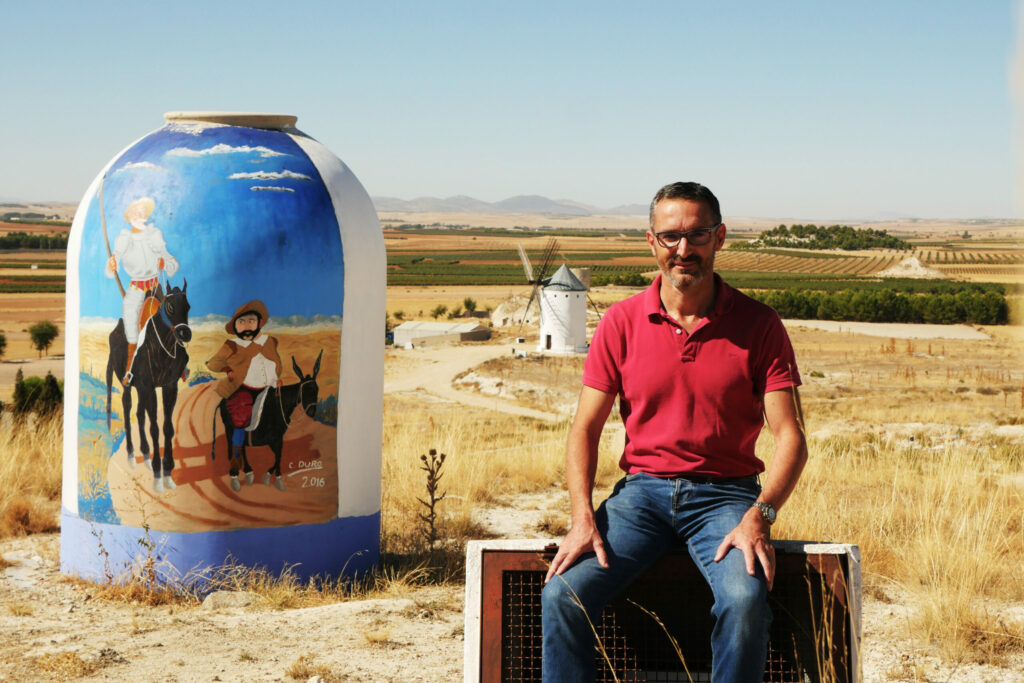 Miguel, producteur de pistaches, est assis devant les champs qu'il cultive